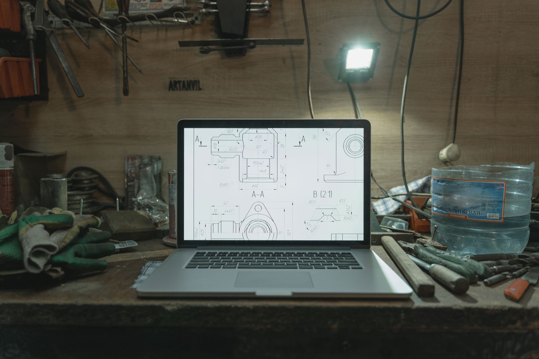 Drawings and plans laid out on a workshop bench