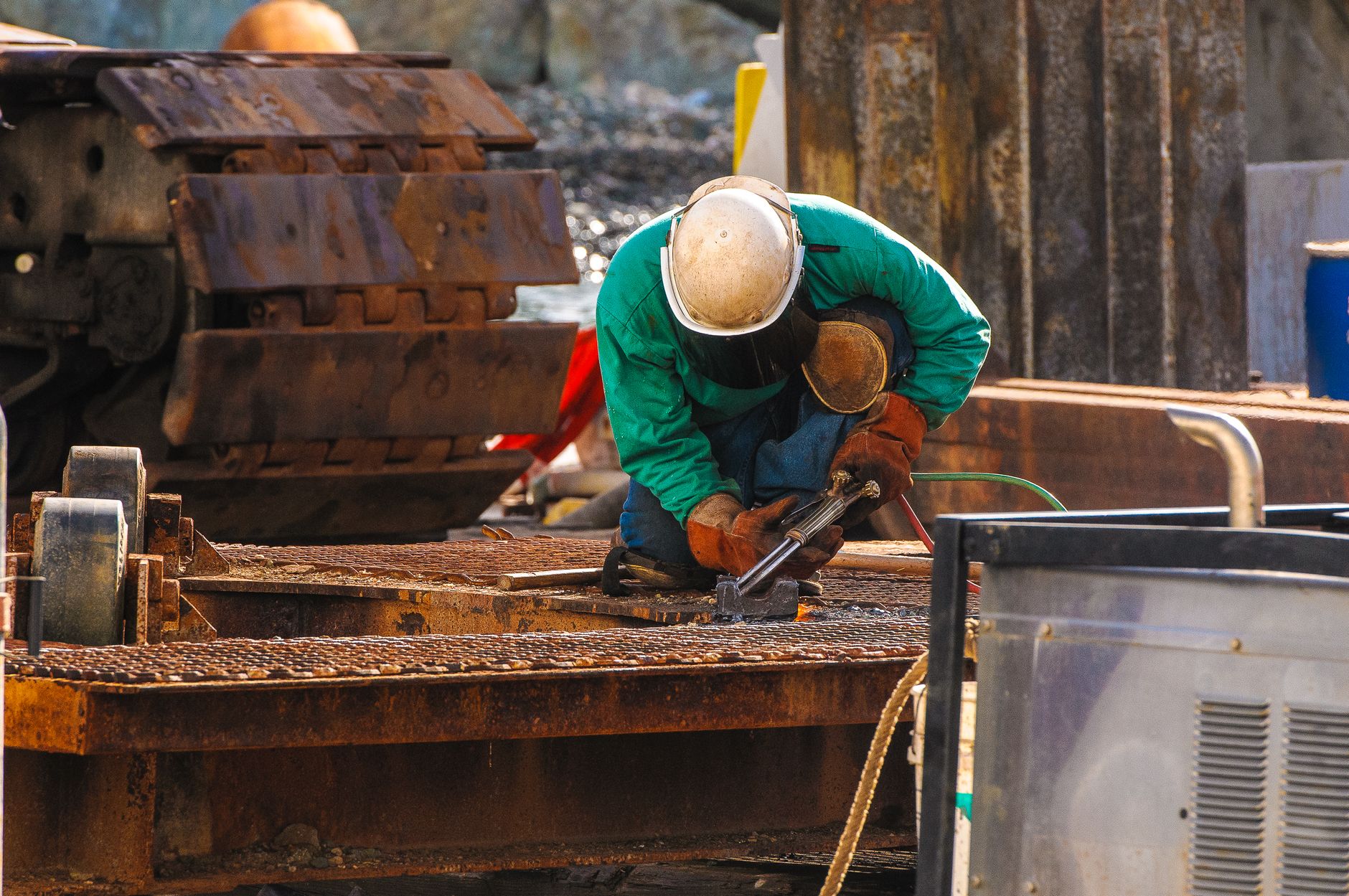 Welder working on site at an outdoor industrial location